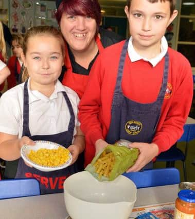 Pupils Rose Carr and Sam Tinsley with school cook Gail Boyce.