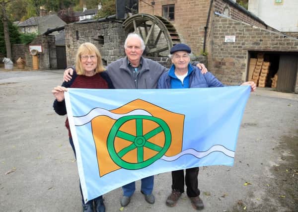 Cromford committee celebrating after having designed and officially registered the Cromford flag. Picturd are Sue Mosley, Clem Wilson, and Ian Evetts.
