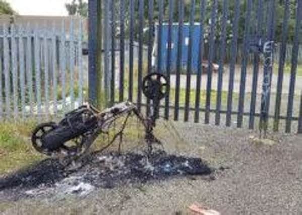 Burnt-out motorbike outside the club gates.