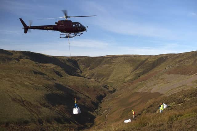 A helicopter delivers bags of stone to Kinder Scout to help repair badly-eroded footpaths. Photo: Rod Kirkpatrick/F Stop Press.