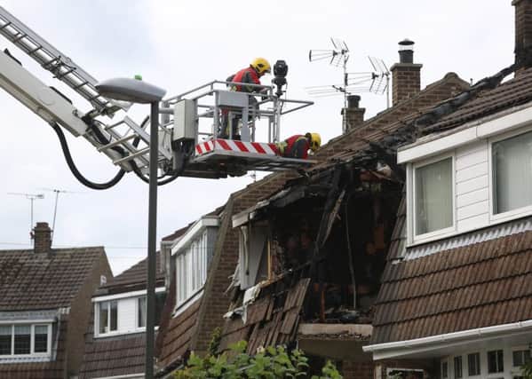 Fire crews are lifted closer to the scene of a fire, in Riddings, near Alfreton, Derbyshire, where a suspected gas explosion took place in the early hours of Sunday 20 September 2015. It is thought that there could have been people in the house when the fire started.