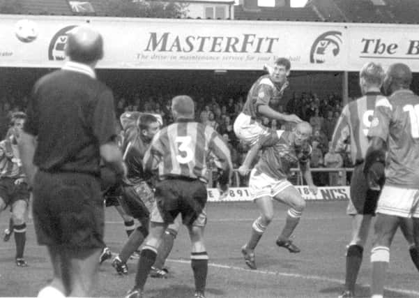 Mark Williams (leaping) heads the ball for Chesterfield FC.
