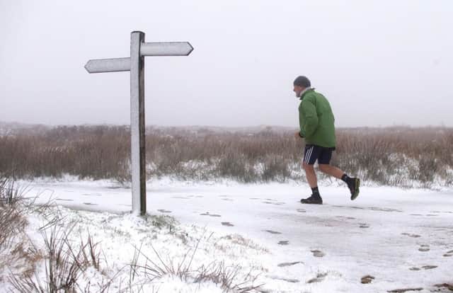 A fell-runner wearing shorts braves snowy conditions as he tackles the Pennine Way over Ashop Moor near Glossop in Derbyshire.