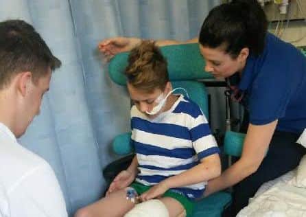 Joe Boyer, 14, pictured in hospital after being hit by a motorbike.