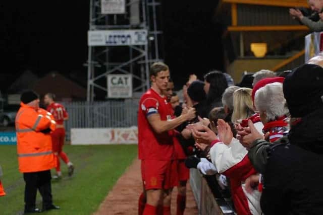 Aden Flint, pictured here celebrating with fans at the end of the Reds' 6-3 extra time FA Trophy second round replay victory at Cambridge United, moved to Swindon Town for Â£150,000 in 2011.