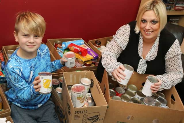 Tom Griffiths and mum Julie with the mountain of donations. Picture: Jason Chadwick.