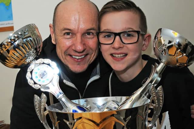 Street dancer James Airey with his dad Paul and a selection of trophies from previous competitions.