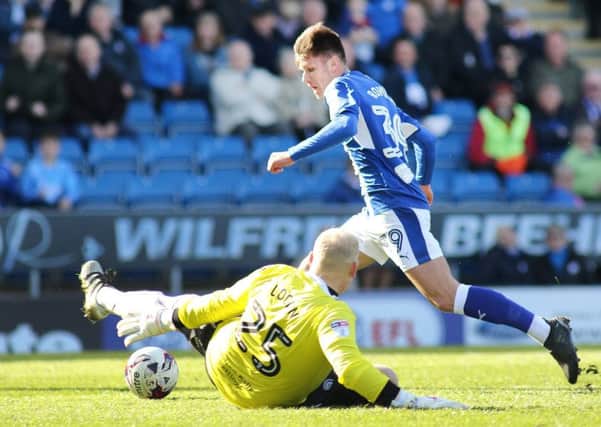 Chesterfield FC v Rochdale, Joe Rowley takes the ball round visiting keeper Logan