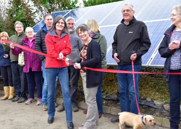 Sarah Fowler, chief executive of the Peak District National Park, cuts the ribbon to launch the solar panels. She is pictured with members of Bamford Community Society.