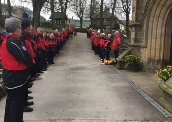 Mountain rescuers from across the Peak District form a guard of honour in the churchyard.