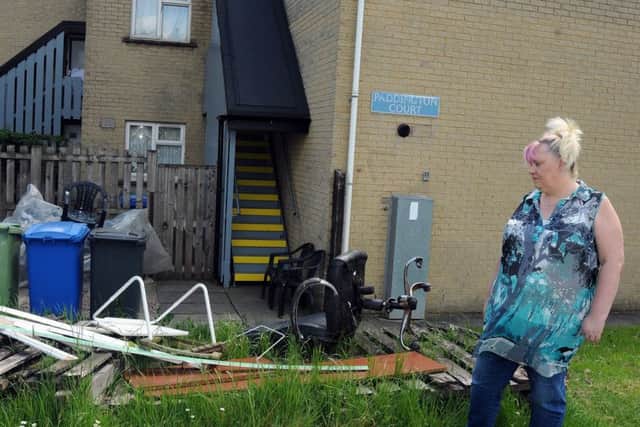 Julie Hall with the broken fence from her Paddlington Court home in Barrow Hill, which has not been removed by the council dispite requests and is attracting other dumped rubbish.