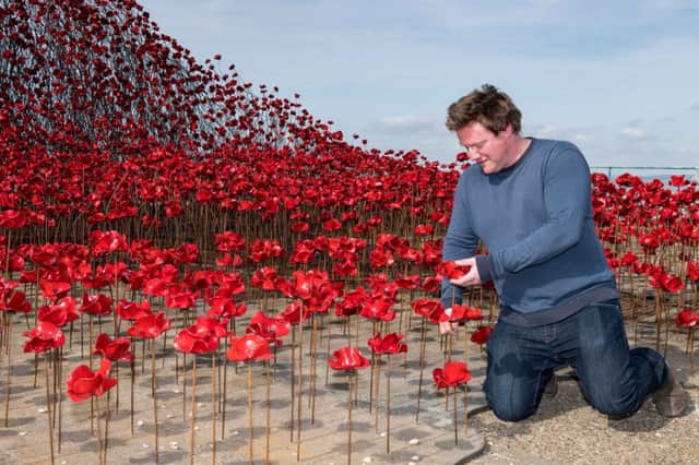 SHOEBURYNESS, ENGLAND - APRIL 11:  Artist Paul Cummins views his poppy sculpture "Wave" at Barge Pier, Shoeburyness, Southend-on- Sea as part of a UK-wide tour organised by 14-18 NOW on April 11, 2017 in Shoeburyness, England.  Wave is part of Blood Swept Lands and Seas of Red by artist Paul Cummins and designer Tom Piper. The full installation of 888,246 ceramic poppies, one to honour every death in the British and Colonial forces of the First World War, was on display at the Tower of London in 2014.  (Photo by Ian Gavan/Getty Images for 14-18 NOW)