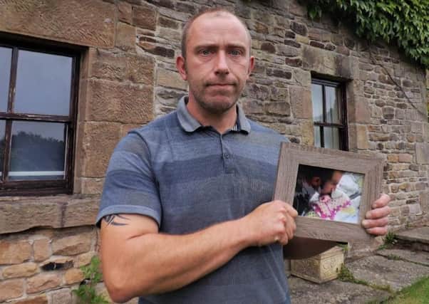 Paul Marchington with a photo of his daughter Evie.