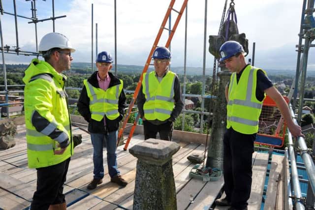 Michael Sheppard, left, the stone conservator and contracts manager at St. Thomas Church chats with visitors who joined his hard hat tour of the tower on Monday evening.