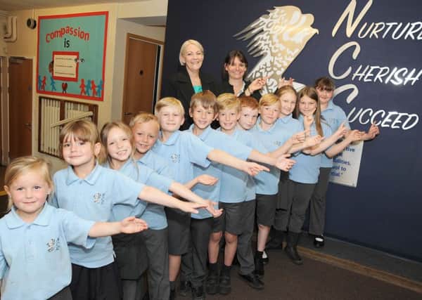 Pupils at the Newbold Church School with their head teacher Kerry Marsh and Chair of Governors Pam Lister, point to their school motto which served them well with Ofsted who has rated them a 'Good' school.