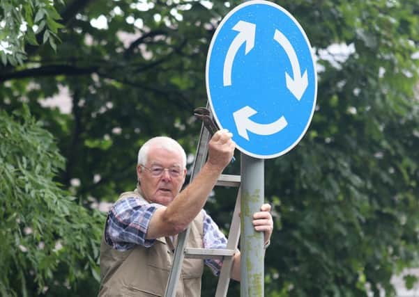 David France turns the sign back towards the traffic after waiting for the county council to do it.