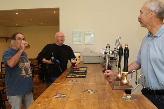 Stephen Eyre welcomes his first two customers on the opening day of his new micro pub in Walton