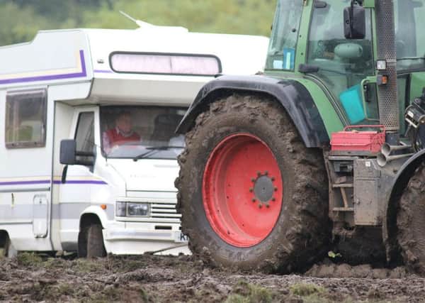 A tractor helps a motorhome negotiate the muddy venue last week.
