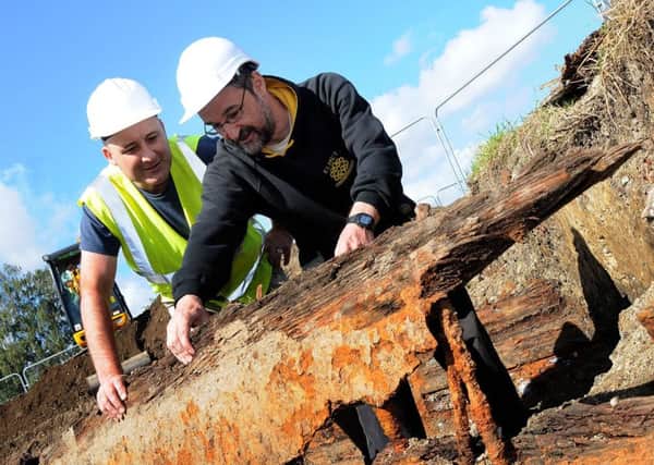 Andy Robinson, the Chesterfield Canal Trust cor-ordinator of community archaeology and Russell Martin French an archaeologist with Elmet inspect on of the two boats unearthed at the Staveley dig.