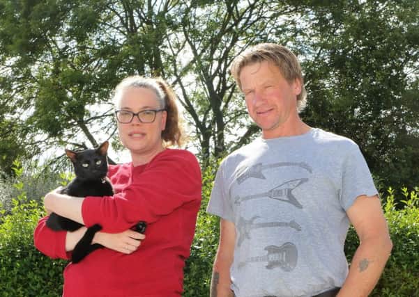 Beetle the cat with owner Sandra Allen and rescuer Gary Barson in front of the tree