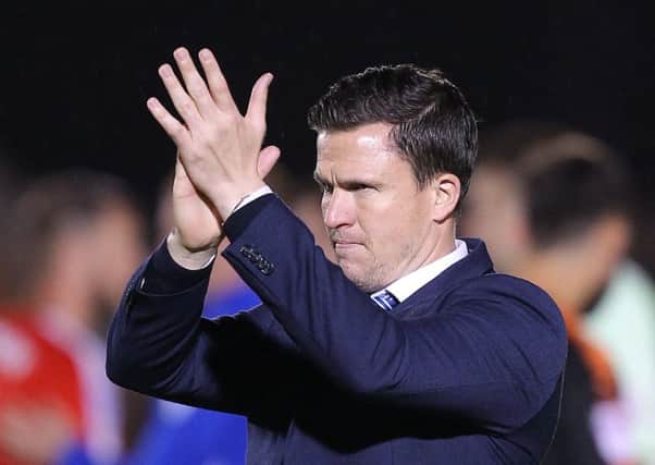 Chesterfield boss Gary Caldwell applauds the away support after a battling draw at Colchester