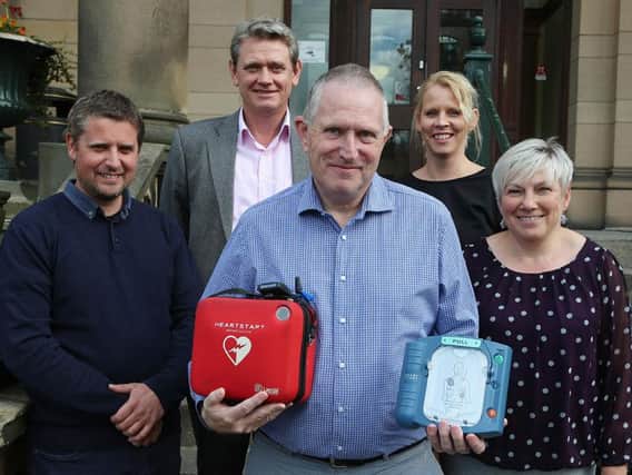 Councillor Simon Spencer, centre, pictured with a defibrillator and the county council staff who helped save him, from left, John Hopkinson, James Adams, Chrissie Edwards and Teresa Jones.