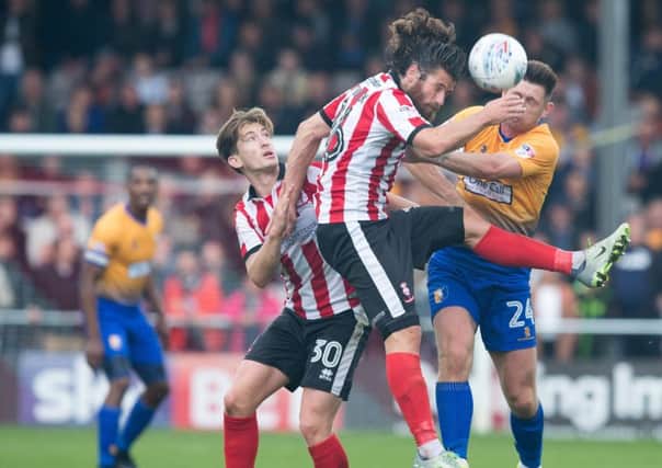 Lincoln City v Mansfield Town - Calum Butcher of Mansfield Town battles with Michael Bostwick of Lincoln City - Pic By James Williamson