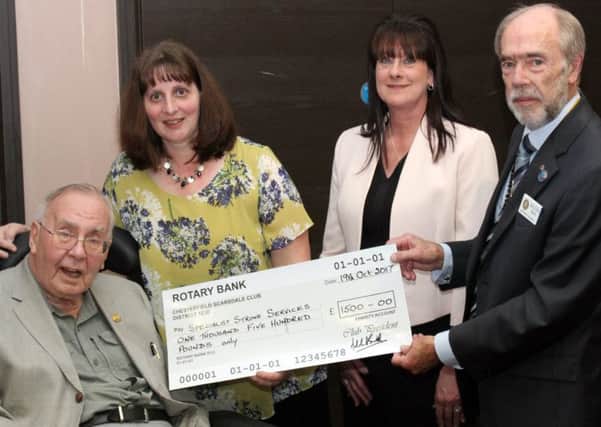 President Malcolm Smith ( right) presents a cheque for Â£1500 to Julie Wheelhouse and Debbie Newton. Looking on  is past president Alan Beasley (left).