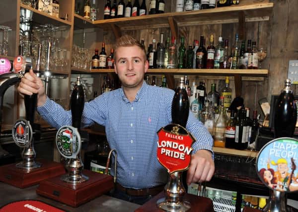 New owner Dan Tomlinson behind the bar at the Black Swan in Idridgehay.