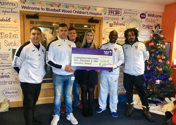 Players from AC Wollaton present the cheque to Lucy Rathbone from Bluebell Wood