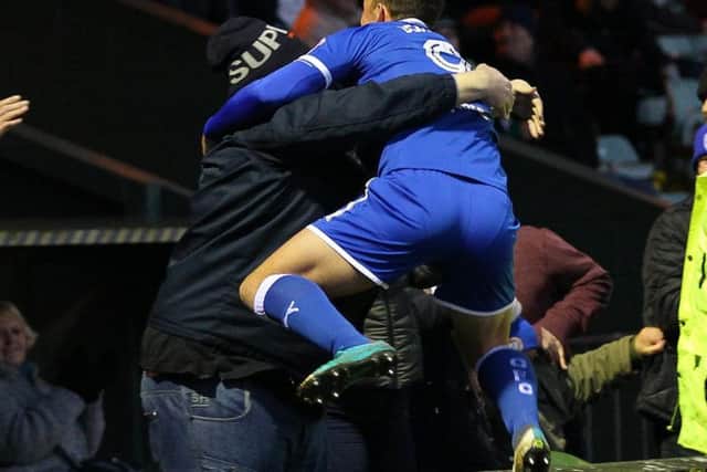 Kristian Dennis leaps into the arms of a Spireites supporter after his winner
