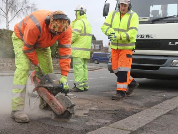 Workmen fixing a pothole in Chesterfield.