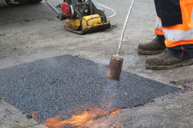 Workmen fixing a pothole on Brockwell Lane in Chesterfield.