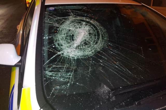The offenders smashed the window of the police car as they fled the scene