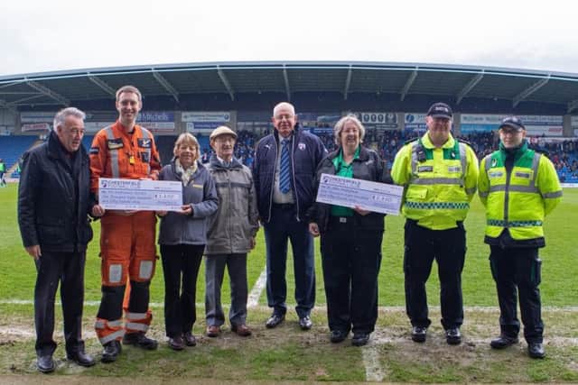 Representatives from the Air Ambulance Service and St John Ambulance receive the proceeds of a collection organised by Chesterfield FC Community Trust. Chesterfield chairman Mike Warner is pictured fourth from the right alongside Alec Freeman, whose life was saved at Chesterfield's game against Lincoln City. Picture by Tina Jenner.
