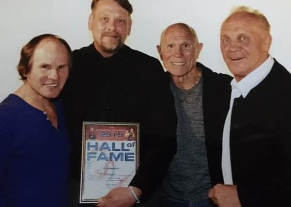 Rob Beeson (second left) receives his award from Benny Urquidez (left), Bill Wallace and Brian Jacks (right).