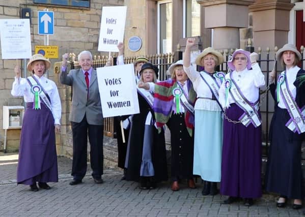 Bolsover WI members dressed as suffragettes chain themselves to the railings outside Old Bolsover Town Council's offices.