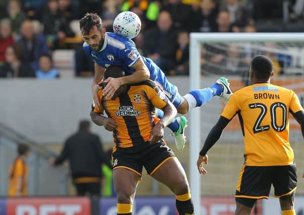 Picture by Gareth Williams/AHPIX.com; Football; Sky Bet League Two; Cambridge United v Chesterfield FC; 21/10/2017 KO 15.00; Cambs Glass Stadium; copyright picture; Howard Roe/AHPIX.com; Spireites skipper Sam Hird leaps with Cambridge's Uche Ikpeazu