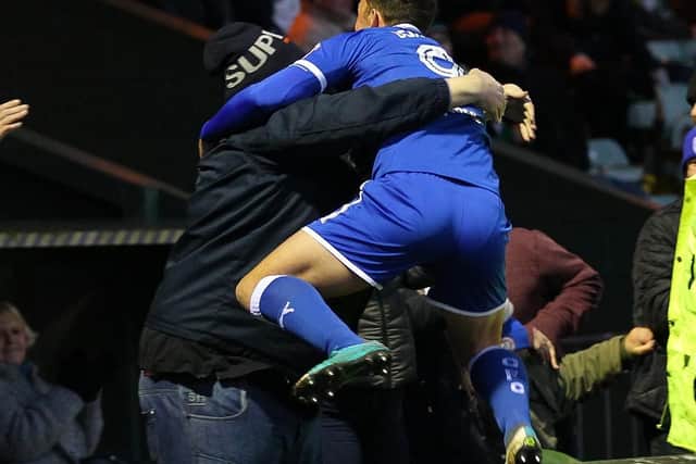 Kristian Dennis leaps into the arms of a supporter after scoring a last gasp winner at Yeovil