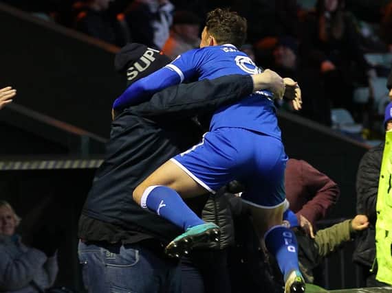 Kristian Dennis leaps into the arms of a supporter after scoring a last gasp winner at Yeovil