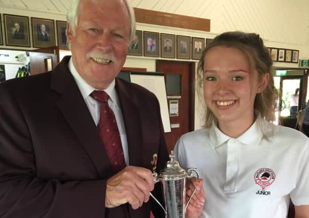 Hannah Gregory receives the Matlock Golf Club Junior Open trophy from captain Steve Bradley.